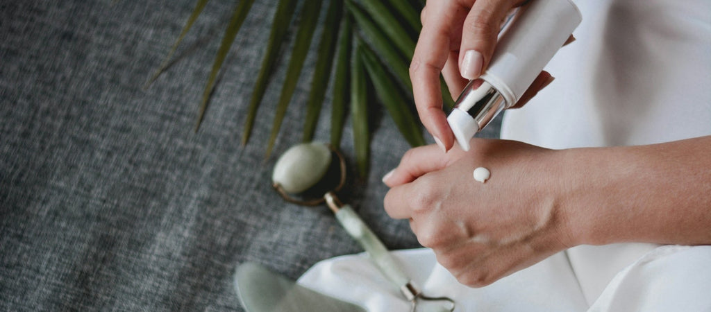 Persona applying skincare cream to their hand.