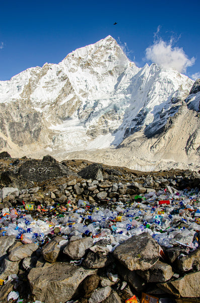 Rocky mountain covered with snow and trash during the daytime.