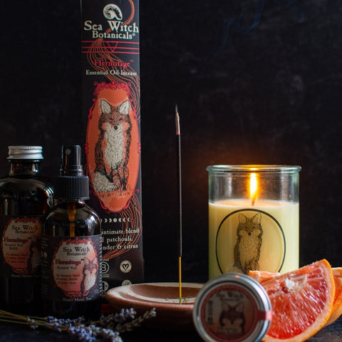 Herbal Renewal gift set with incense, spray, solid perfume, and candle, pictured with fresh lavender and grapefruit, incense and candle burning.