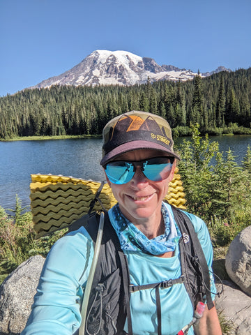 Heather taking a selfie in front of a lake and Mt. Rainier