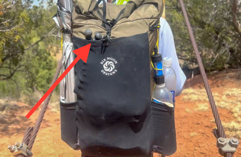 Tripod in the back pocket of a backpack