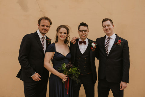 A groom, his groomsmen and best woman pose for a photo in Portugal, the best woman is wearing a Henkaa Convertible Dress in Navy Blue to match the groomsmen.