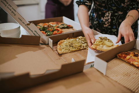 A couple share pizza with their wedding party between the photoshoot and the reception.