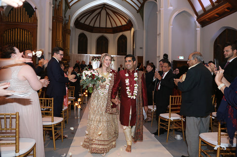 Stephanie Rochefort and Subhir Uppal walk down the aisle hand-in-hand after their multicultural wedding at allsaints Event Space in Ottawa Ontario, Canada.