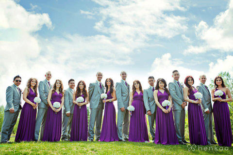 Wedding party wearing Henkaa Plum Purple Sakura Maxi Convertible Dresses and matching Henkaa ties and holding white flower bouquets