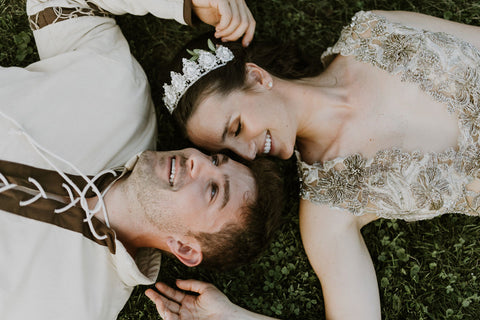 Alex and Lauren Melnik lay on the grass as husband and wife during tasteful medieval themed wedding featured on the Henkaa infinity dress blog.