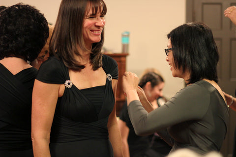 Sonia adjusting a performer's choir dress before the show