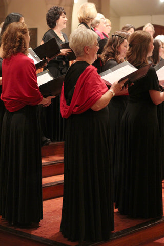 Oriana Women's Choir singing on stage, wearing Henkaa's choir dresses