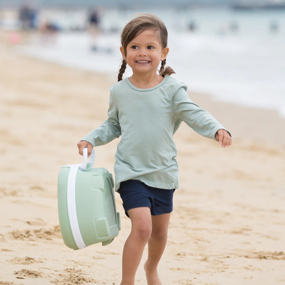 Girl holding potty on beach