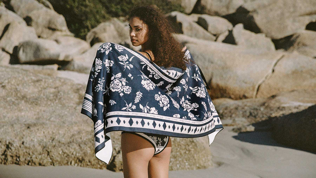 A girl enjoying the sun with Aria swimsuit and beach towel