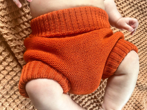 orange disana wool on a baby
