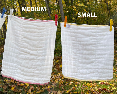 compare small and large prefolds drying on a clothes line