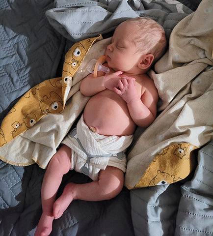 size newborn muslin flat neat fold on a new baby