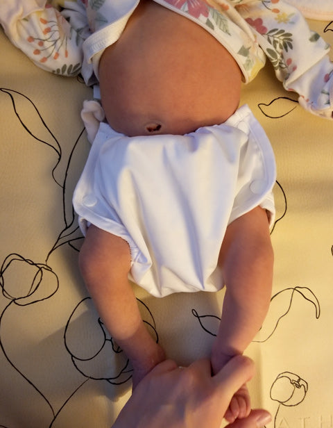 newborn baby in white POSO cloth diaper cover