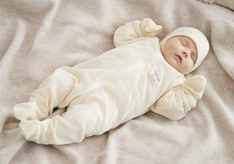 Ruskovilla merino wool baby body suit with sleeves on a baby