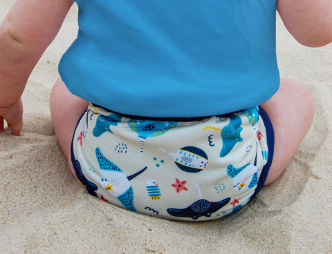 swim diaper on baby at beach