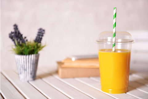 plastic up with orange juice in kitchen setting