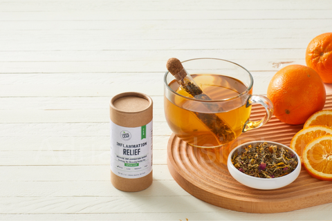 inflammation relief loose leaf tea brewed with the fresh tea leaves, orange slices and canister