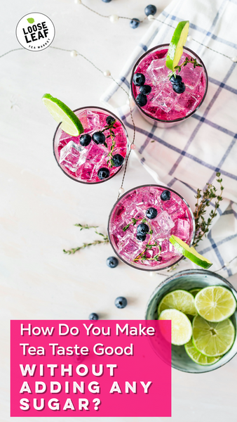 Tasty tea garnished with berries, lime, and herbs.