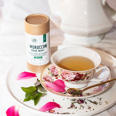 brewed moroccan rose mint in a china tea cup with fresh mint and fresh rose petals