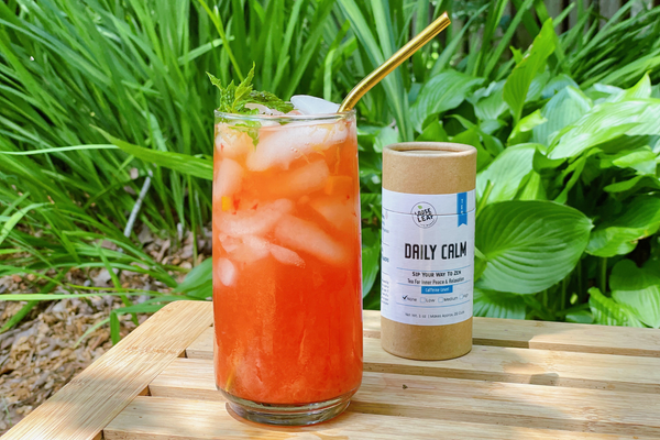 delicious calming tea punch in a tall glass, with Daily Calm tea canister