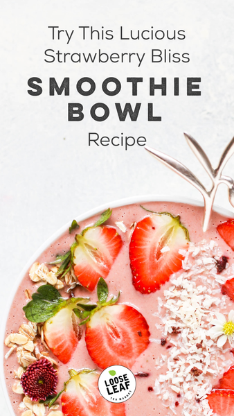 strawberry smoothie bowl garnished with strawberries, coconut, and flowers