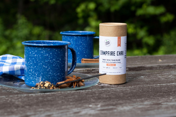 Campfire Chai and two blue mugs on a picnic table.