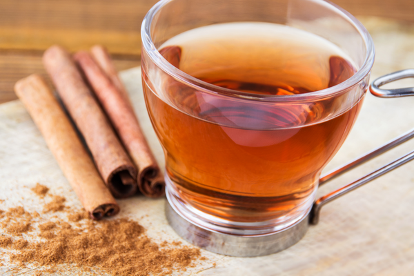 cinnamon tea in a glass mug with cinnamon sticks and cinnamon powder; cinnamon tea for weight loss
