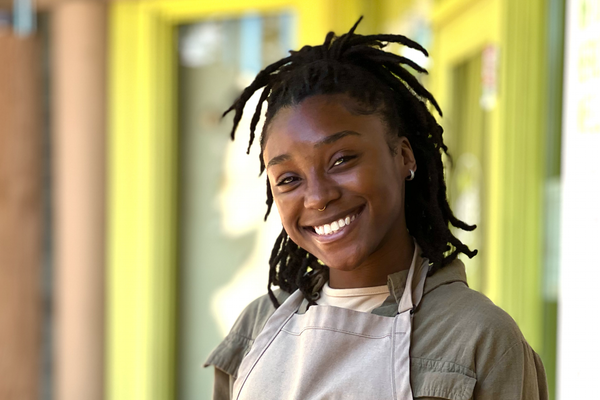 Smiling woman in front of a green doorway.