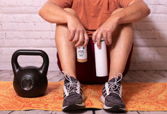 man holding gingseng green dragon canister and water bottle at the gym