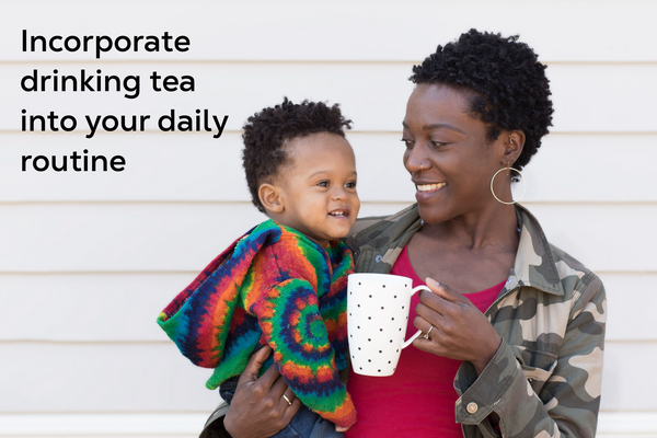 Mother holding her baby with a cup of tea.