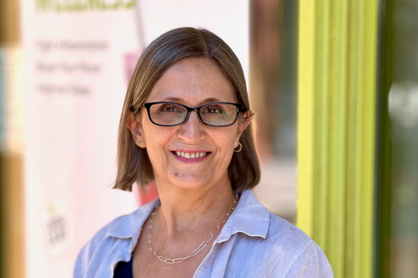 Woman wearing glasses standing outside of a shop.