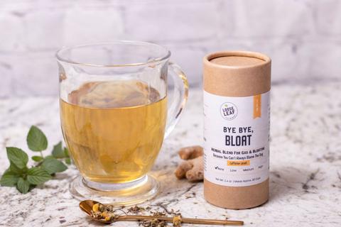 bloating tea brewed in mug with tea canister on side in kitchen setting