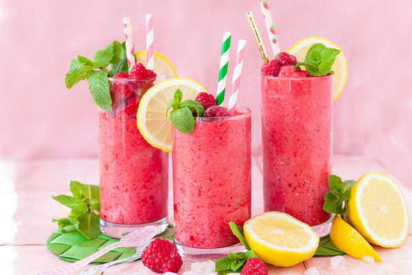 berry smoothie with lemon slices, fresh berries, and mint