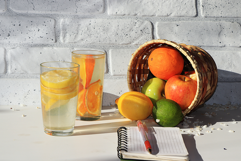 fresh fruit in a bowl, water glasses and notebook for inflammation