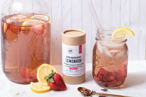 strawberry lemonade tea brewed, with fresh strawberries and fresh lemons in kitchen setting