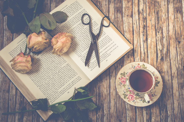 Cup of tea with book and dried flowers.