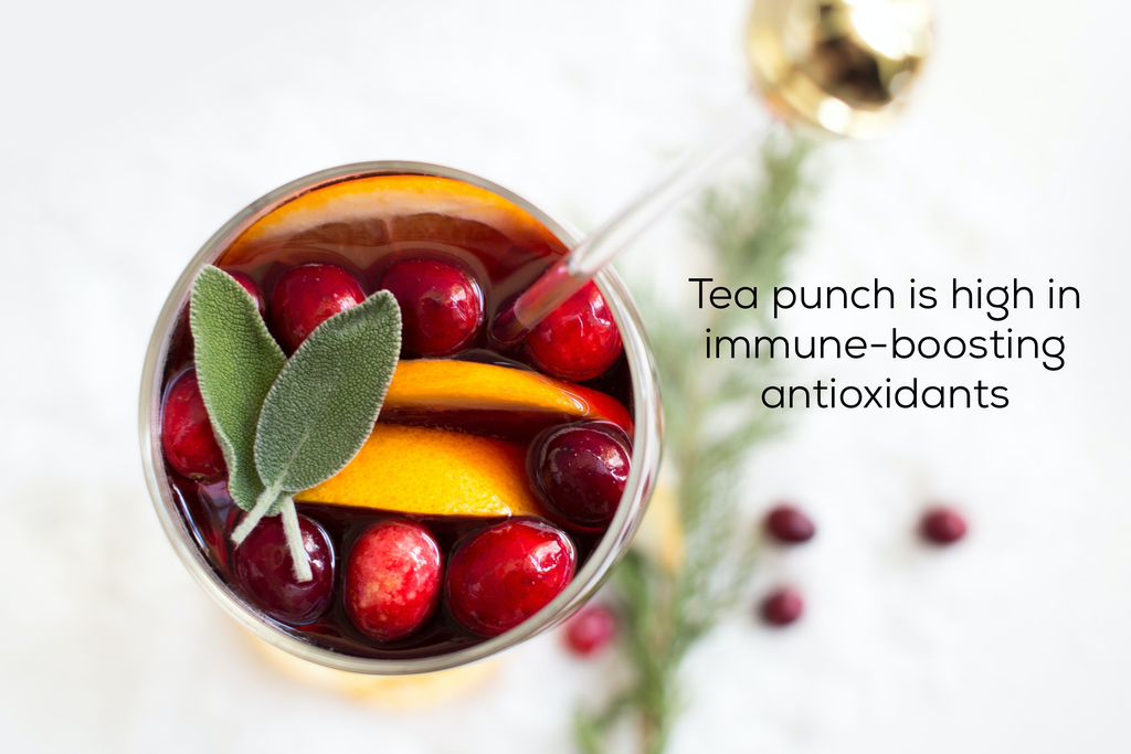 tea punch garnished with fruit and herbs