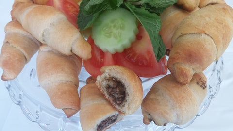 zaatar crescent rolles recipe - readu tp serve rolles on glass plat with cucumber, tomato and fresh mint decorations