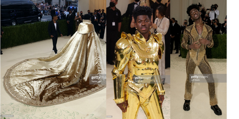 Lil nas x in three different looks. The first is a long train golden cape that looks like it came from royalty. The comes off to reveal a golden armor full body suit. Lastly the suit cracks open to reveal a black slim bodysuit that has golden bedazzle detailing covering every part. 