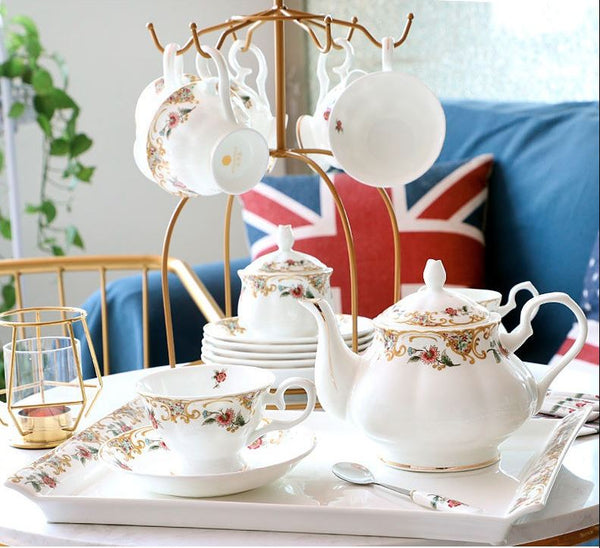 BestLeafTea English Afternoon Tea Set: White teapot, sugar bowl, milk jar, teacups, and spoons with gold outlines, adorned with red flowers and green leaves. Presented in a gift box