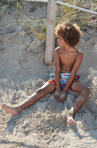 boy sitting in beach sand