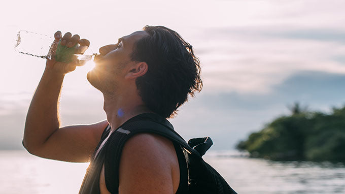 man drinking from water bottle