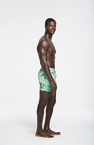 man wearing palm frond swim trunks