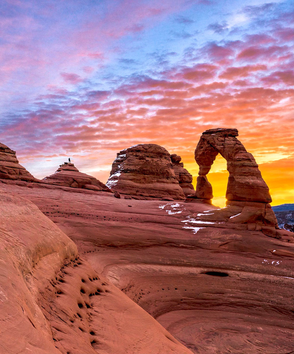 Delicate Arch in Arches National Park with a colorful sunset in the background