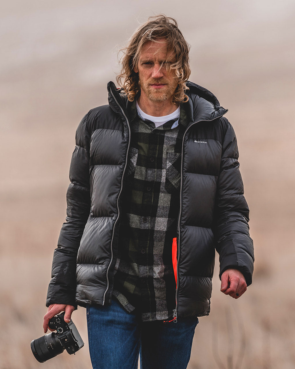 Matthew Van Horn walking on Antelope Island, Utah carrying a camera.