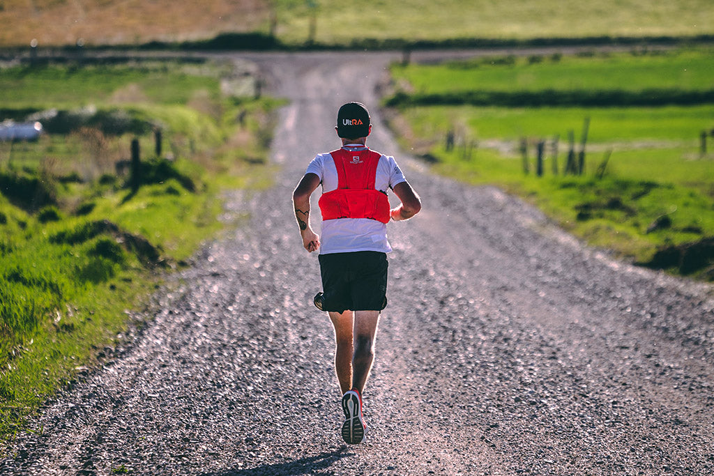 Ultra endurance athlete Michael Mcknight running down country dirt road near Utah-Idaho border.