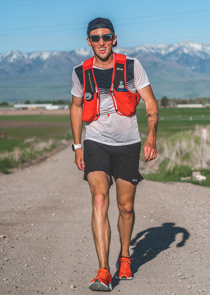 Runner Michael Mcknight wearing his trademark sunglasses on country road with Bear River mountain range in background.