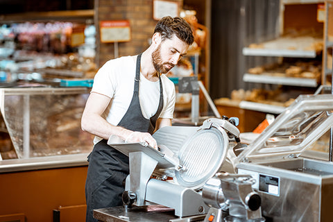 Man Using Slicer in Supermarket