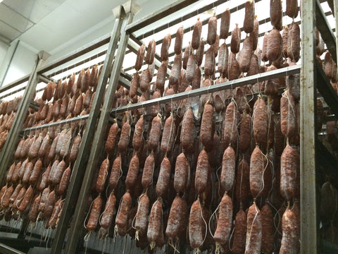 hanging salami on dry racks in full dry room